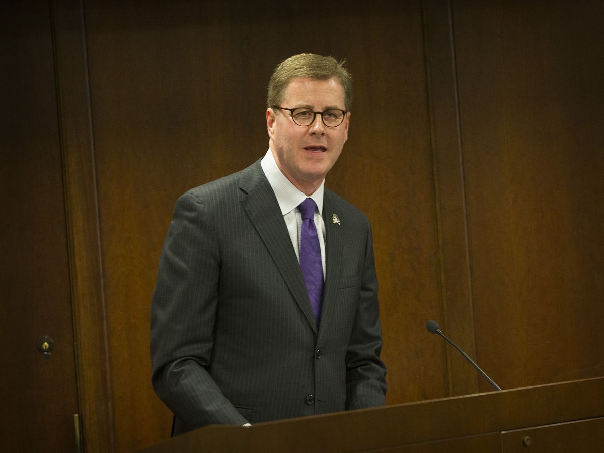 Dr. Cecil P. Staton speaking at a wooden podium